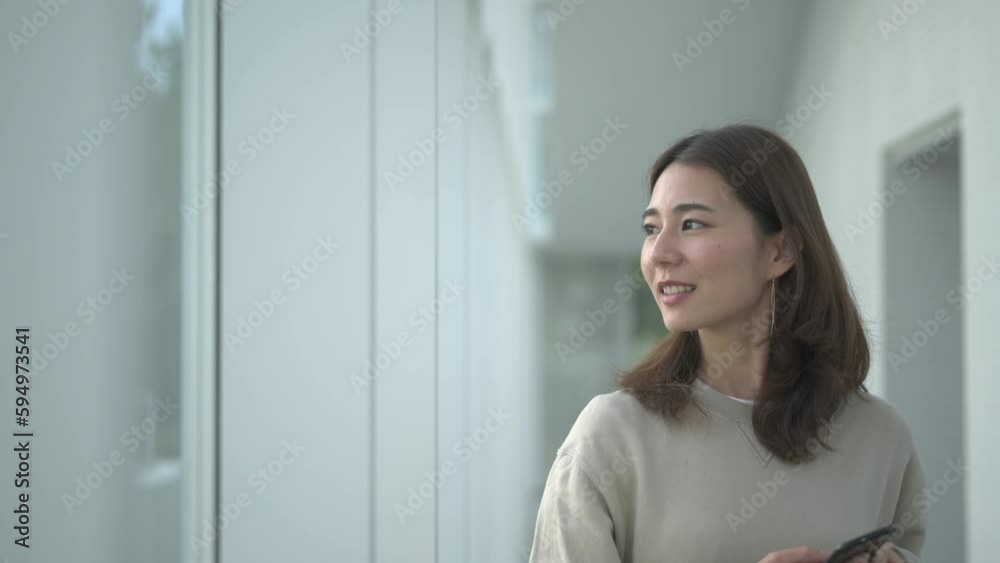 スマートフォンを持って景色を眺める女性 スマートフォンを持って景色を眺める女性