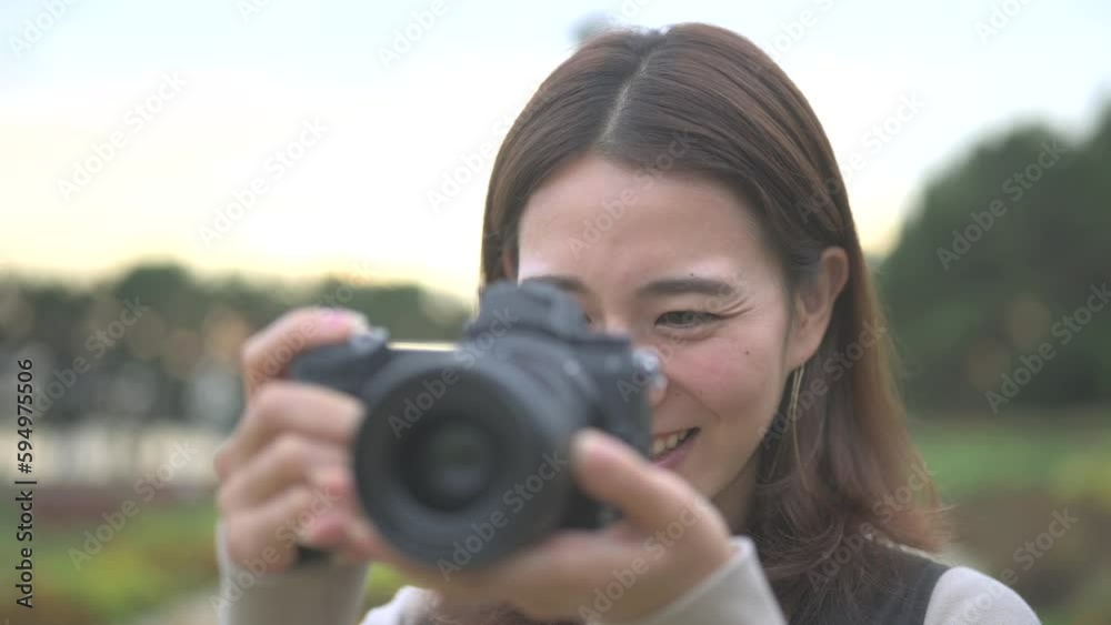 公園でカメラで写真を撮る笑顔の女性 公園でカメラで写真を撮る笑顔の女性