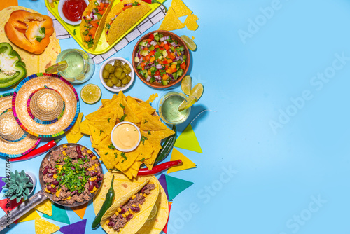 Cinco de mayo party food. Mexican holiday Cinco de mayo traditional dishes  snacks  tortilla corn chips  nachos  tacos  salsa  sauces. Friends and family feast background top view copy space
