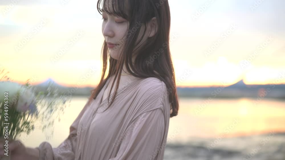 夕暮れの河川敷でブーケを抱えた可愛らしい女性