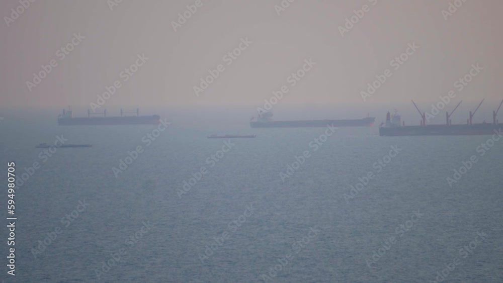 Extreme zoom shot of cargo ships in the middle of Arabian sea as seen from Goa in India. POV of Ships in the middle of the ocean as seen from the dirty binoculars. Transportation via sea background. Extreme zoom shot of cargo ships in the middle of Arabian sea as seen from Goa in India. POV of Ships in the middle of the ocean as seen from the dirty binoculars. Transportation via sea background.
