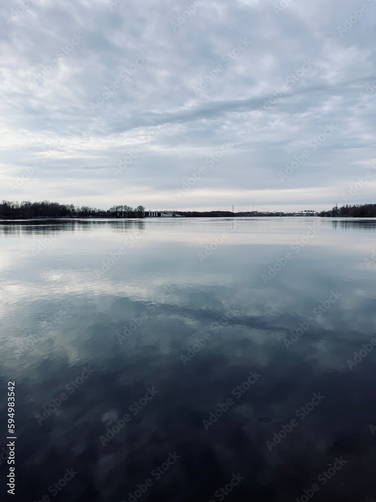 Sky reflection on the river surface, riverside, cloudy weather, natural river view