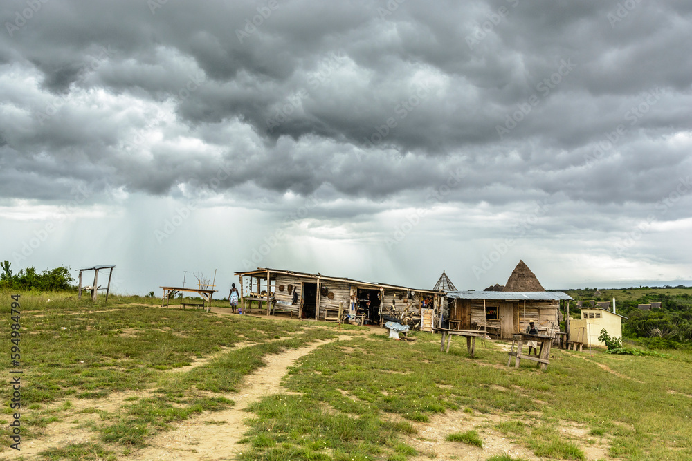Fototapeta premium Regenwolken über einfachen Holzhütten, Queen Elizabeth Nationalpark, Uganda, Afrika