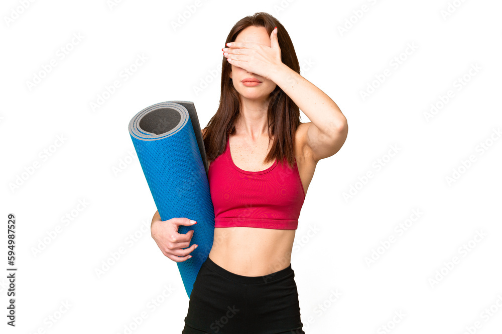 Young sport caucasian woman going to yoga classes while holding a mat over isolated chroma key background covering eyes by hands. Do not want to see something