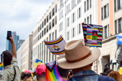 Christopher Street Day Berlin.Pride, 23 July 2022. LGBT flags hang colourful on a hat. Men surrounded by people in the background during a demonstration. Celebration in the street. Pride parade Berlin