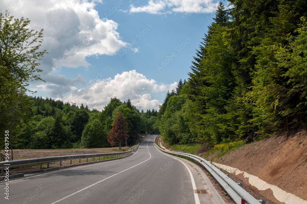 highways in the mountains against the background of the sunny sky and the white clouds