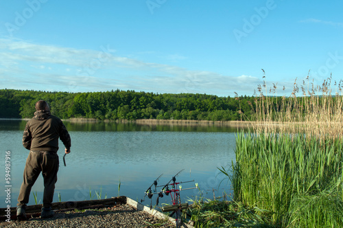 a fisherman throws a fishing rod into a large lake