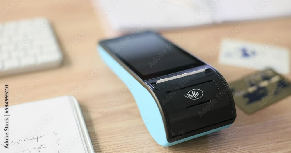 A wireless banking pos terminal on the table, close-up, slowmotion. Modern equipment for payment, acquiring
