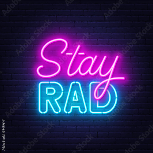 Stay Rad neon quote on brick wall background.