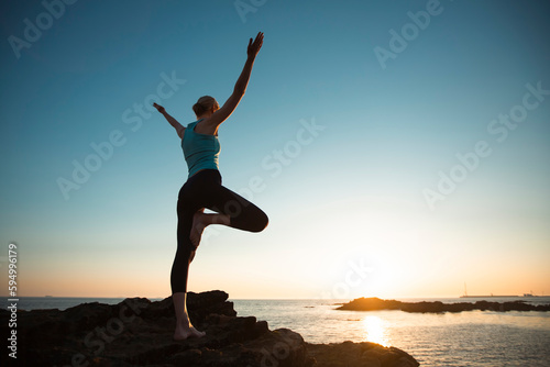 Yoga woman on the oceanfront during a lovely sunset.