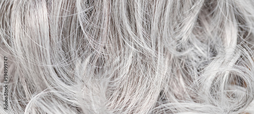 Close-up of ash blonde dyed hair, toned curls background