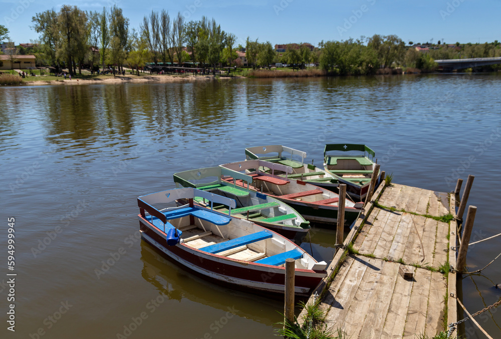 Coloridas barcas de madera amarradas en un pequeño pantalán en el río Duero a su paso por la ciudad de Zamora. Coloridas barcas de madera amarradas en un pequeño pantalán en el río Duero a su paso por la ciudad de Zamora.