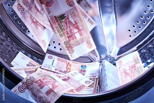 Russian banknotes in the washing machine. Money laundering, financial fraud concept