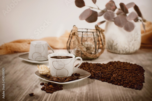 Espressotassen und aus Kaffeebohnen ein Herz formiert. 