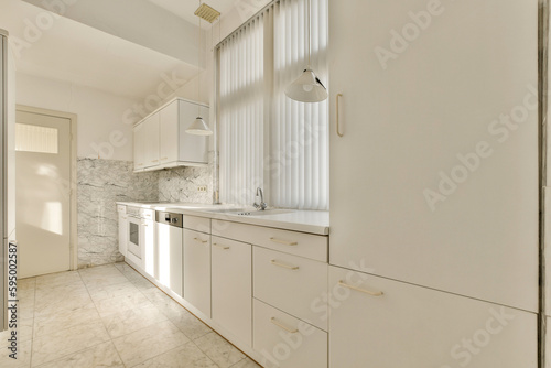 a kitchen area with white cabinets and marble counter tops on the floor  along with an open door that leads to another room