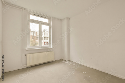 an empty room with white walls and no one person standing on the floor in front of the window looking out to the street