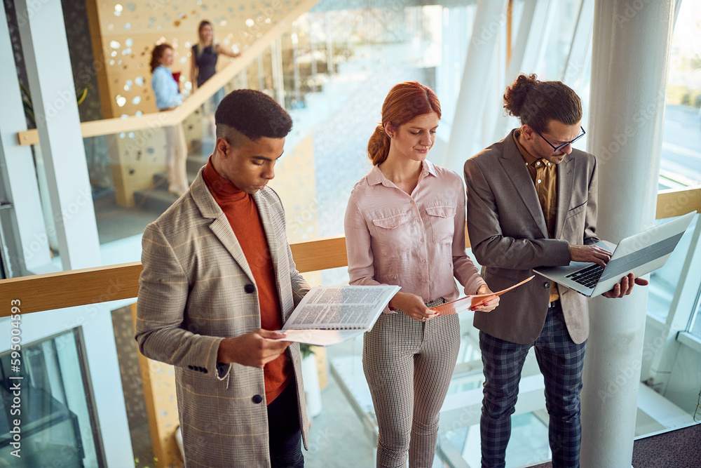 Young business people are standing in the hallway and reading some documents about work. Business, people, company Young business people are standing in the hallway and reading some documents about work. Business, people, company