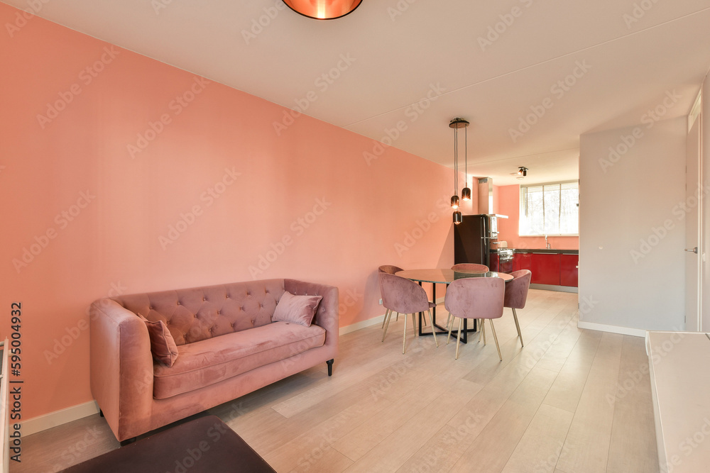 Fototapeta premium a living room with pink walls and white flooring in the center of the room is a couch, two chairs and a table