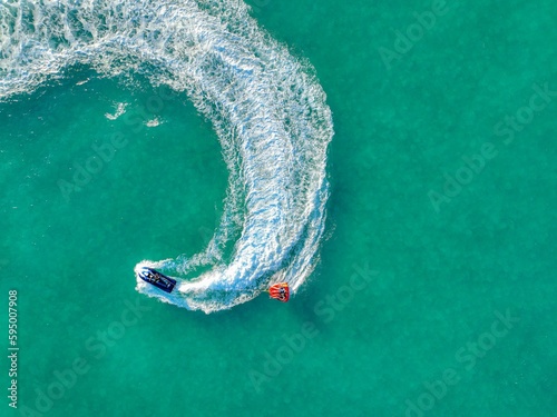 Aerial top view of a speed boat navigating the open ocean performing thrilling tricks and maneuvers