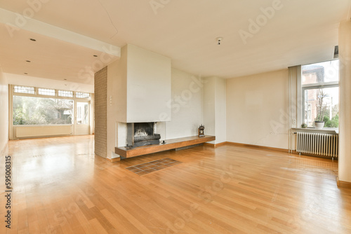 an empty living room with wood flooring and large windows looking out onto the cityscaped in the distance