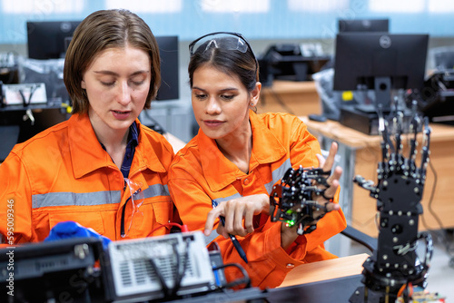 Girl engineer in robot industry fabrication research room simulate testing robot arm on operation