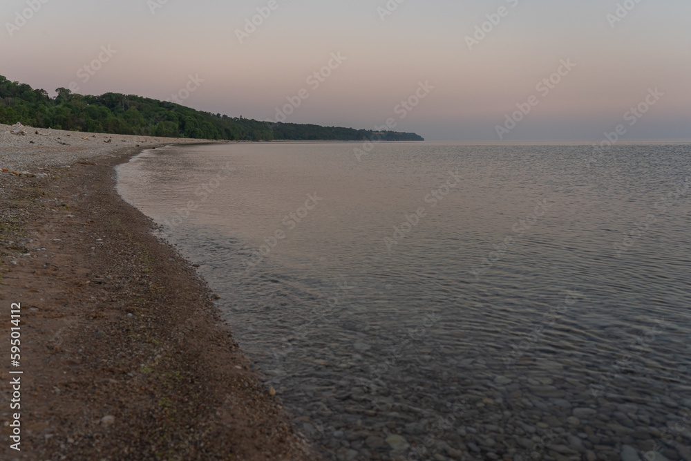 Pebble beach in Toila oru, Estonia. Evening on the coast of the Gulf of Finland. The sun has set. Natural background. Space for text. Pebble beach in Toila oru, Estonia. Evening on the coast of the Gulf of Finland. The sun has set. Natural background. Space for text.