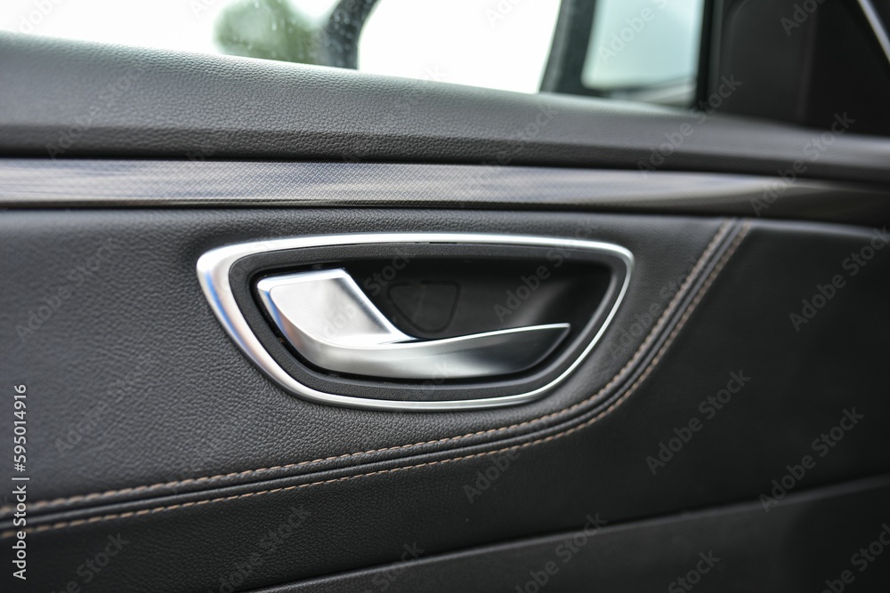 Silver automobile door handle with a leather covered interior