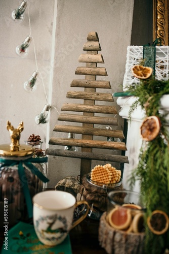 Festive wooden Christmas tree surrounded with holiday decorations