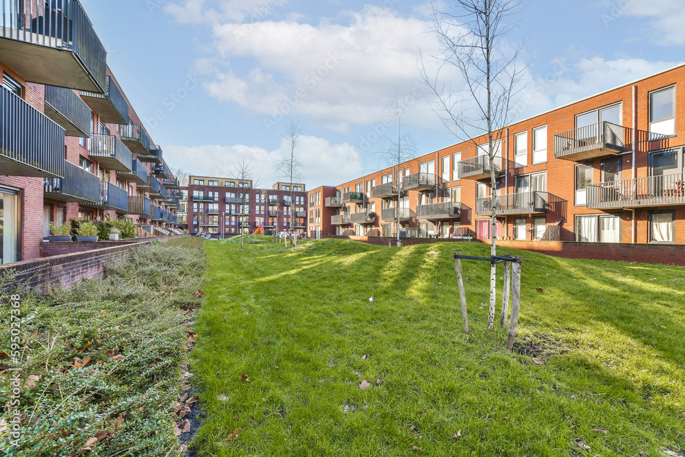 an apartment complex with green grass and trees in the foreground area on a bright sunny day photo crediton / shutterstocker
