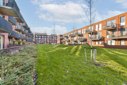 an apartment complex with green grass and trees in the foreground area on a bright sunny day photo crediton / shutterstocker
