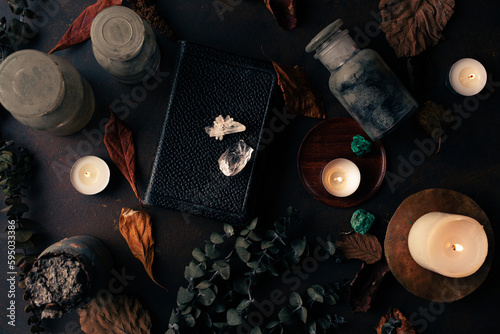 Witchcraft still life concept with potion, spell book, herbs ingredients candles and magical equipment