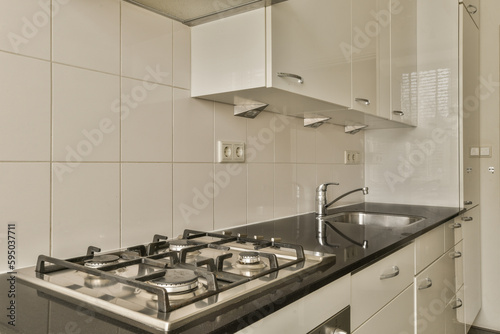 a kitchen with black counter tops and white tiles on the wall behind it is an oven, sink and dishwasher