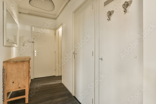 an empty room with a wooden chair and mirror on the wall next to the door  it is very clean