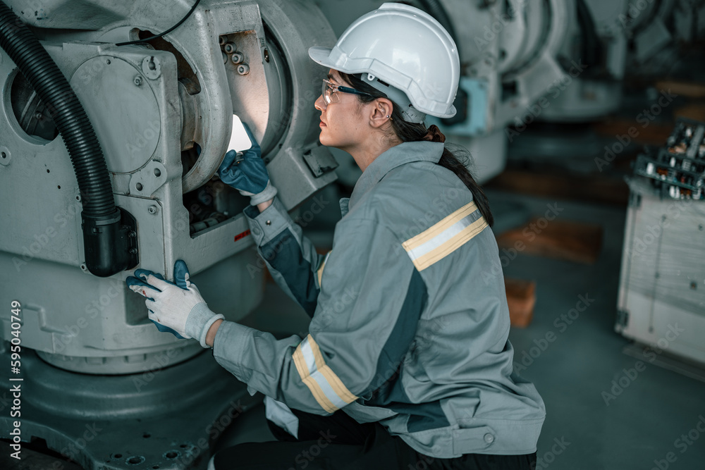 Skilled robotic technician spots the light on robotic components to do protective and corrective maintenance. Inspecting complex mechanical systems. Repairing and troubleshooting to resolve issues. Skilled robotic technician spots the light on robotic components to do protective and corrective maintenance. Inspecting complex mechanical systems. Repairing and troubleshooting to resolve issues.
