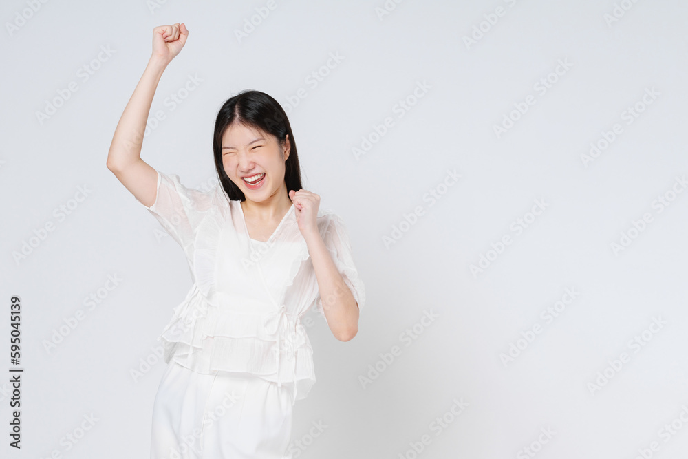 Young asian woman with raised hands celebrating success isolated on white background. Young asian woman with raised hands celebrating success isolated on white background.