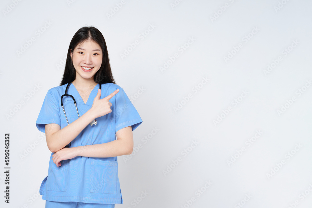 Smiling asian female doctor pointing with hand on copy space isolated on white background. Smiling asian female doctor pointing with hand on copy space isolated on white background.