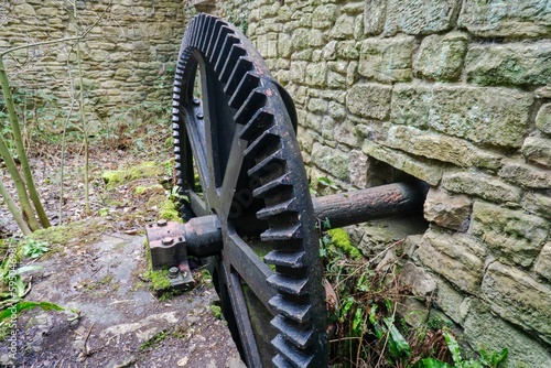 Old cast iron water mill gear cog, in the ruined mill at Jesmond Dene, Newcastle upon Tyne, UK photo