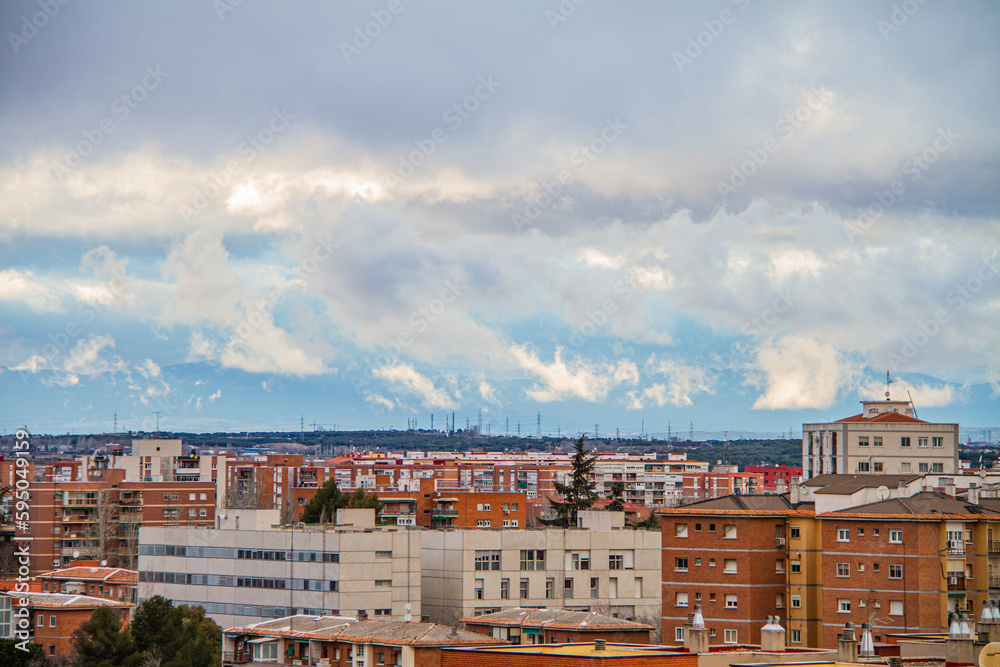 Skyline of the city of Madrid with cloudy sky and sierra mountains in the background