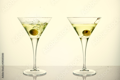 Two glasses of martini with olives.