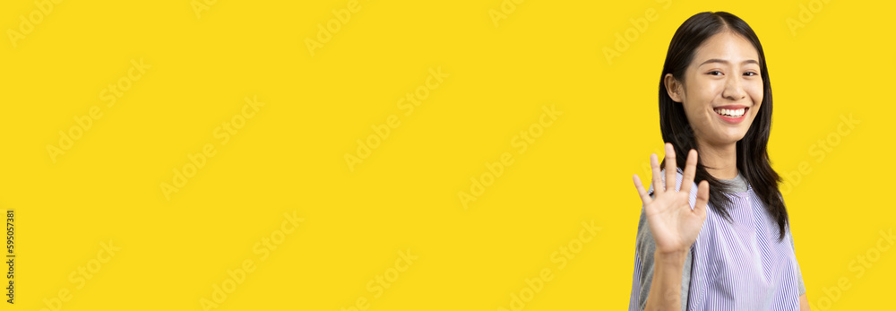 Φωτογραφία Waving hand in hi, Asian woman smiling friendly greeting, Hello,nice to meet you,say hi, Say hi and greet you, Welcome new people Join a multicultural team, Goodbye, Isolated on yellow background