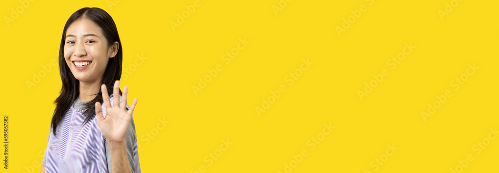 Φωτογραφία Waving hand in hi, Asian woman smiling friendly greeting, Hello,nice to meet you,say hi, Say hi and greet you, Welcome new people Join a multicultural team, Goodbye, Isolated on yellow background