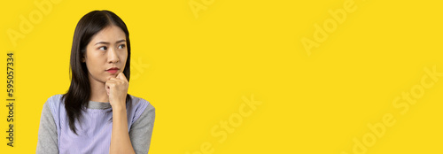 Billede på lærred Young Asian woman thinking hard or planning to do something, Overthinking or worrying, Have a headache, Migraine, Stress, Free space for advertising or promoting products, Copy space, Enter text