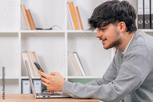 student with mobile phone or smartphone at desk