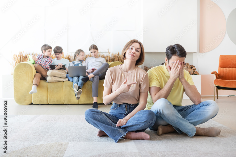 Young Mother of many Children holding pregnancy test and feeling stress because of its positive result and her shocked husband sitting close to her Young Mother of many Children holding pregnancy test and feeling stress because of its positive result and her shocked husband sitting close to her