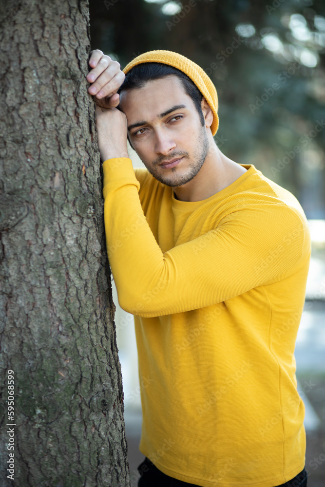Close-up portrait of sensitive man standing and touching the tree. Earth Day and ecological crisis concept Close-up portrait of sensitive man standing and touching the tree. Earth Day and ecological crisis concept