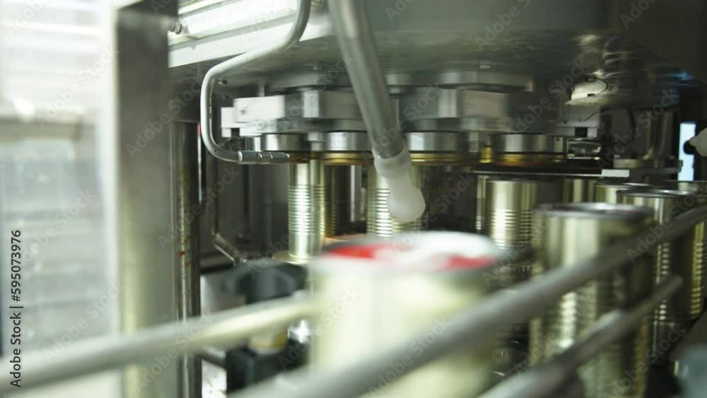Tomato sauce cans filling machine in a canned food production facility Tomato sauce cans filling machine in a canned food production facility