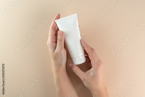A woman's hand holding a white cube of cream, serum, gel for face care. Cream mockup. Marketing product presentation