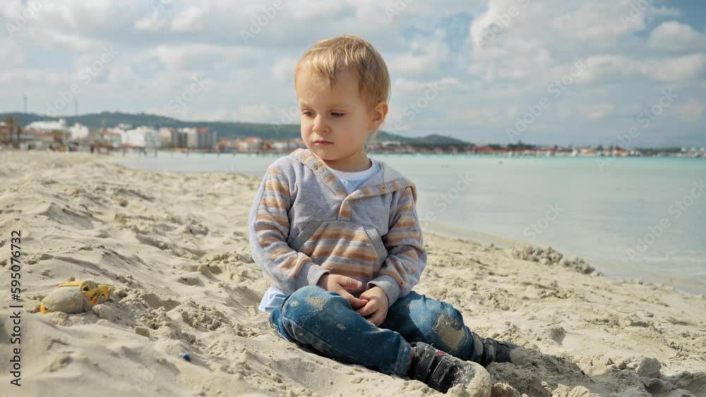 Little toddler's boy beach holiday, playing in the sand. Concept of tourism, travel, summer vacation.