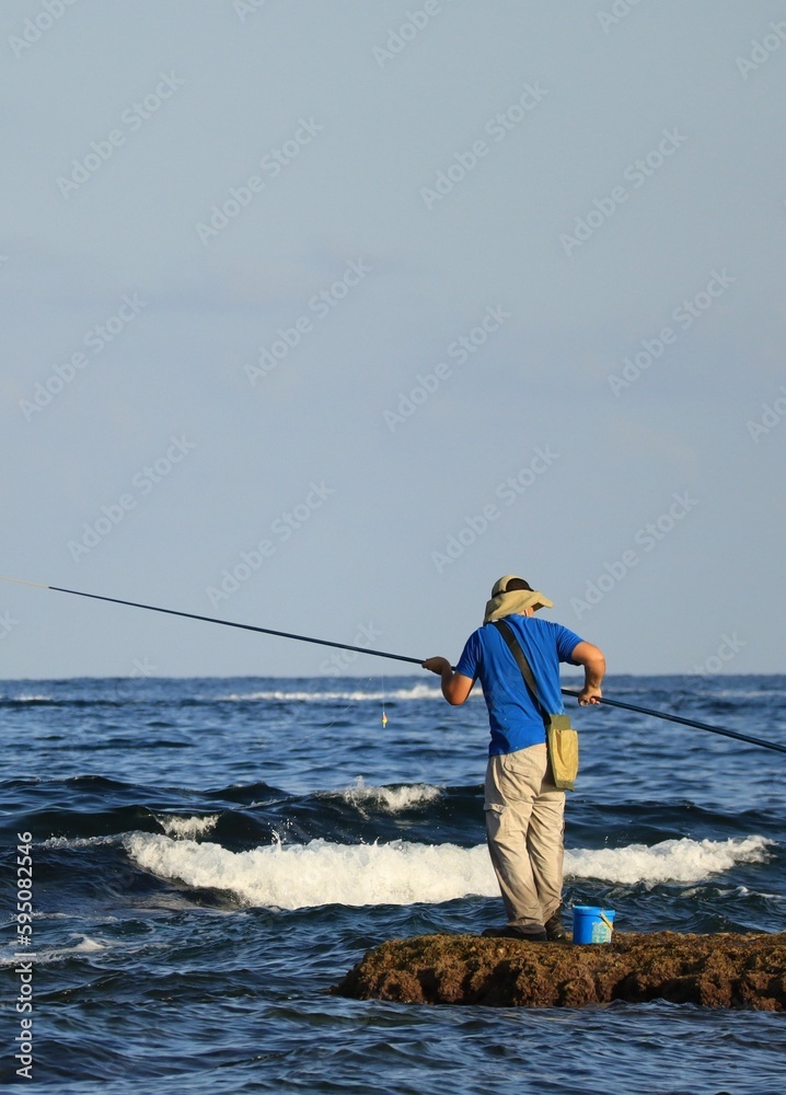 A fisherman in a blue t-shirt and a blue basket