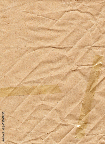 Beige wrapping paper with diagonal folds, chaotic wrinkles, adhesive tape